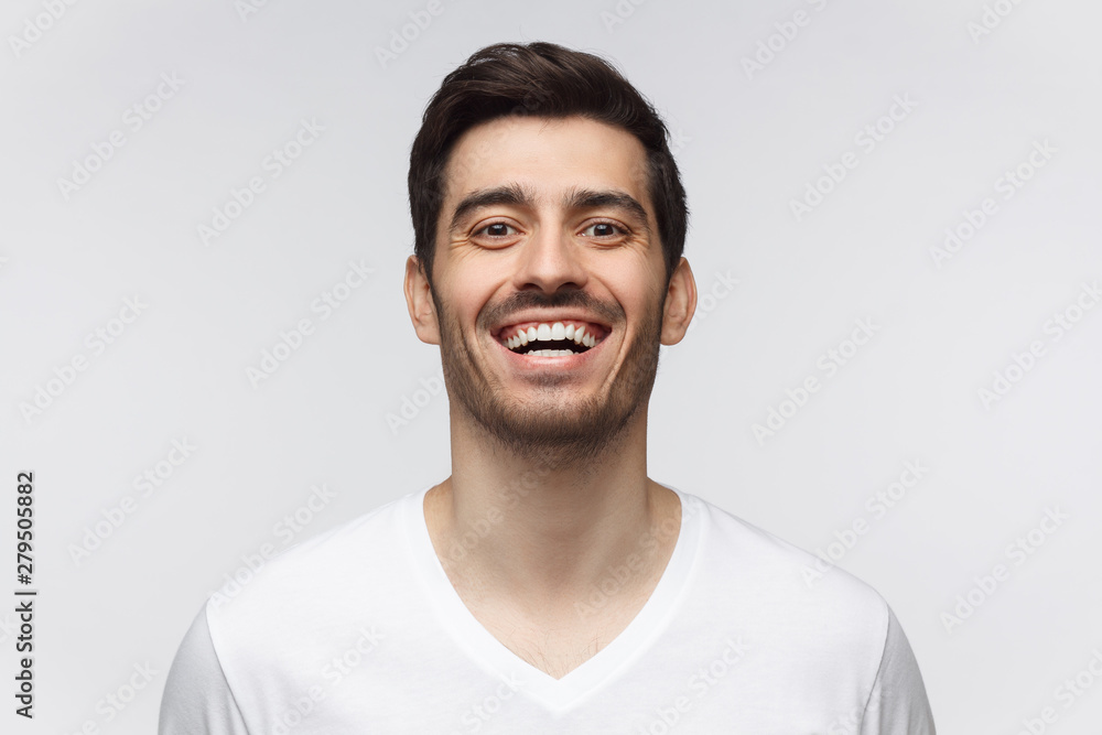 Joyful young man in casual t-shirt smiles broadly, laughing, showing perfect white teeth. Laughing out loud. Joyful young man in casual t-shirt smiles broadly, laughing, showing perfect white teeth. Laughing out loud.