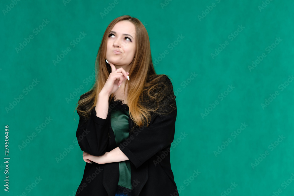 Concept portrait for a belt of a pretty girl, young woman with beautiful brown hair and in a black jacket and green T-shirt on a green background. In the studio in different poses showing emotions. Concept portrait for a belt of a pretty girl, young woman with beautiful brown hair and in a black jacket and green T-shirt on a green background. In the studio in different poses showing emotions.
