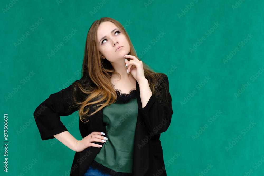 Concept portrait for a belt of a pretty girl, young woman with beautiful brown hair and in a black jacket and green T-shirt on a green background. In the studio in different poses showing emotions. Concept portrait for a belt of a pretty girl, young woman with beautiful brown hair and in a black jacket and green T-shirt on a green background. In the studio in different poses showing emotions.