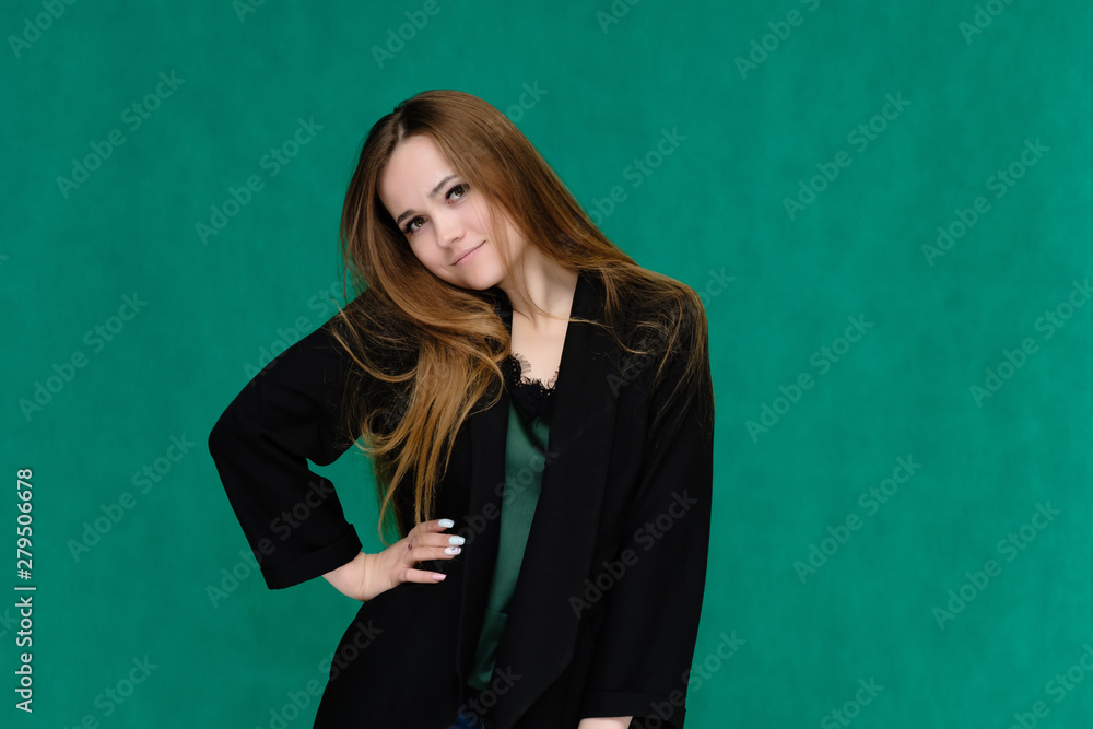 Concept portrait for a belt of a pretty girl, young woman with beautiful brown hair and in a black jacket and green T-shirt on a green background. In the studio in different poses showing emotions. Concept portrait for a belt of a pretty girl, young woman with beautiful brown hair and in a black jacket and green T-shirt on a green background. In the studio in different poses showing emotions.