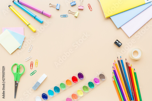 School supplies stationery, colour pencils, paints, paper on pastel orange background, back to school concept with free copy space for text, modern elementary education. Kids desk, flat lay, overhead