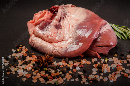 closeup big beef raw heart served with spices and rosemary