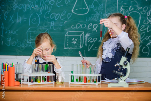 Chemical analysis. Test tubes with colorful substances. School equipment for laboratory. Girls on school chemistry lesson. Kids busy with experiment. School education. School laboratory partners