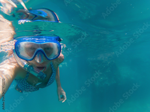 woman taking a selfie snorkeling in clear tropical waters - active holiday