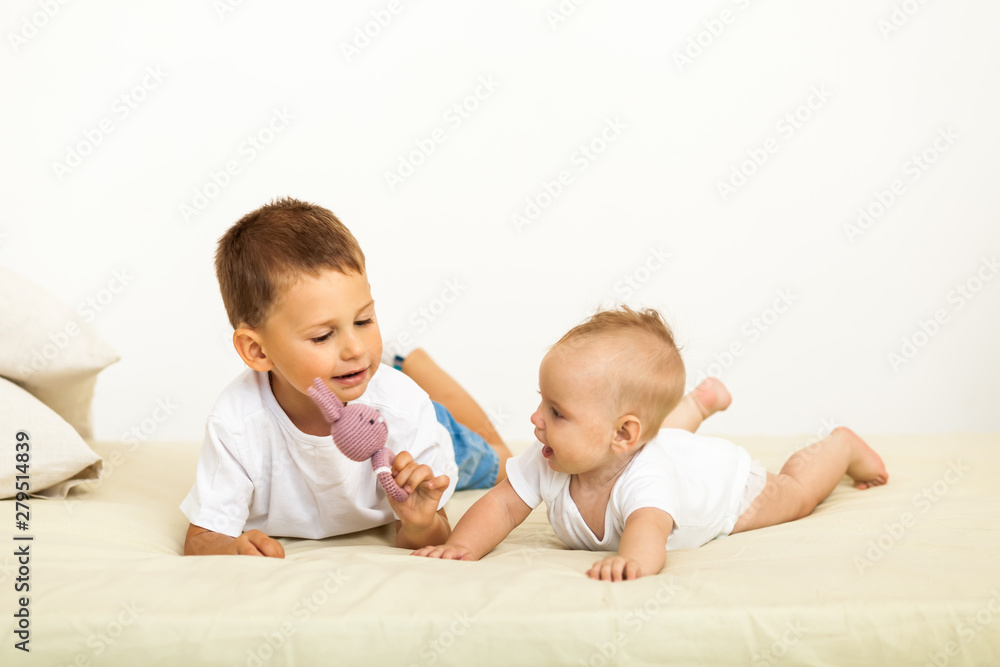 Portrait of brother and sister. Two cute children lying on bed Portrait of brother and sister. Two cute children lying on bed