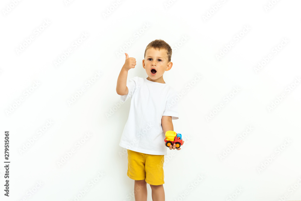 Portrait of a little boy laughing with thumbs up sign on gray background Portrait of a little boy laughing with thumbs up sign on gray background