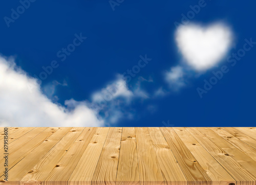Brown plank wooden board as shelf with blurry heart shaped white soft cloud and fresh blue sky in natural background. Beautiful texture and pattern of table   s panels build from reused woods pallet.