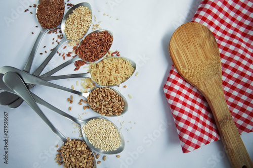 Seven spoon with grains and variations of rice with traditional italian napkin in the background