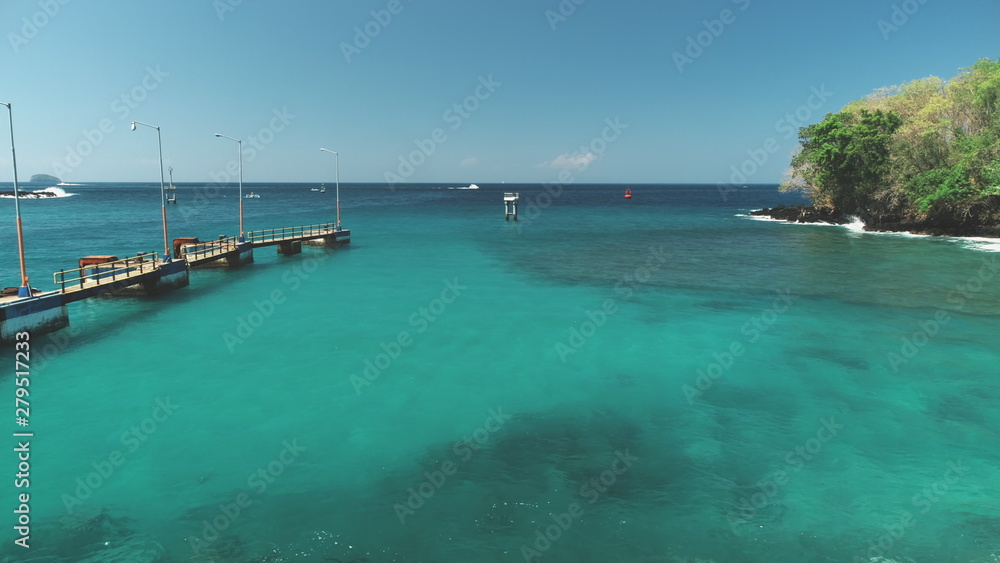 Nature Landscape. Turquoise Crystal Ocean Water with Calm Waves, Harbor, Port, Pier in Bright Sunny Day. Travel Transport Relax Tourism Concept. Tropical Paradise Bali Island, Indonesia. Cinematic