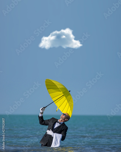 A lonely businessman with a yellow umbrella under a lonely cloud