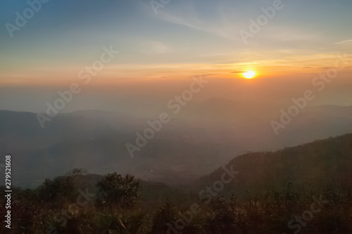 Mountain view morning of top hill around with soft fog and yellow sun light in the sky background, sunrise at top of Phu Ruea National Park, Phu Ruea District, Loei Province, Thailand. photo