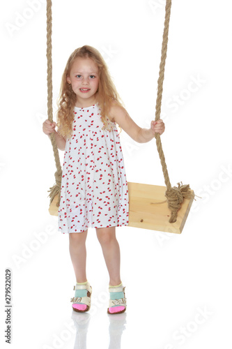 Little girl swinging on a swing. Isolated on white background