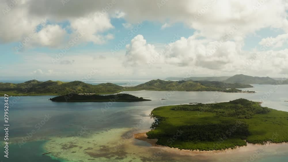 Tropical island covered with forest surrounded by an atoll and a coral reef. Bucas grande, Philippines. Summer and travel vacation concept. Tropical island covered with forest surrounded by an atoll and a coral reef. Bucas grande, Philippines. Summer and travel vacation concept.