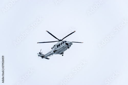 A lage white helicopter flying overhead
