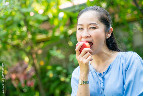 Portrait of beautiful middle aged asian women holding apple in park