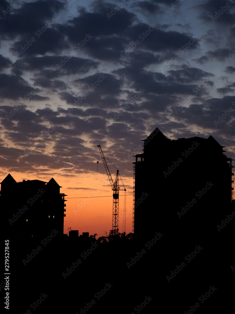 Fototapeta premium tower crane work, in the evening on the construction site