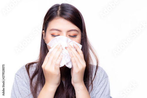 Beautiful asian woman has a cold or flu. She feel sick and dizzy. Pretty girl blowing nose by using tissue paper. She has nasal congestion or stuffed nose and running nose. She get sinusitis disease
