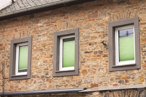 Three windows with green shutters in a brick wall  Germany  Europe 