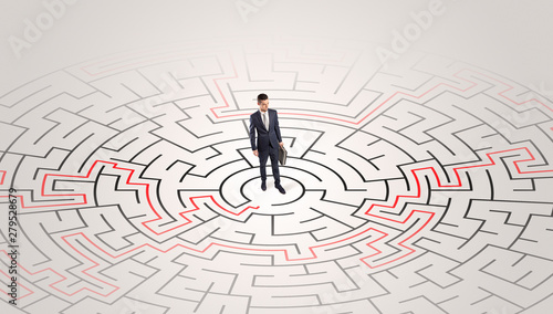 Young entrepreneur standing in a middle of a labyrinth with the solution