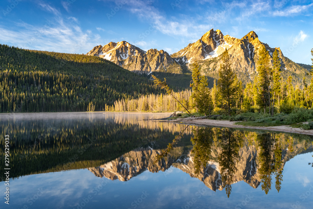 Stanley Lake in the Sawtooth National Forest at sunrise with mountain reflection in water