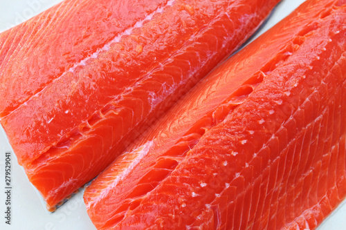 Wild-caught sockeye salmon fillets on a white background.