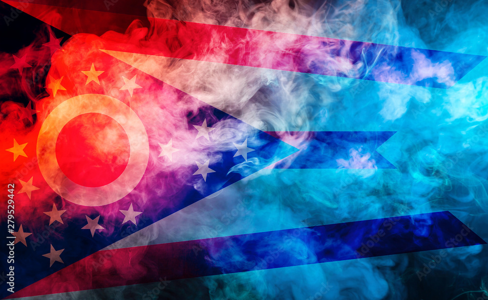 The national flag of the US state Ohio in against a gray smoke on the day of independence in different colors of blue red and yellow. Political and religious disputes, customs and delivery.