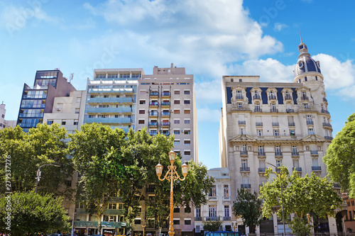 Skyline of historic and modern buildings in Buenos Aires, Argentina, surrounded by green trees, against a blue summer sky.