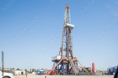 Land oil drilling rig blue sky .Land rig during the drilling operation . Oil and gas drilling rig onshore dessert with dramatic cloudscape .