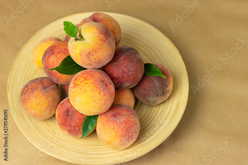 Ripe peaches in a plate on a wooden background. Close-up peaches Healthy food concept, plant background, natural eco-products, organic food, vegetarian, vegetables, raw, festival food