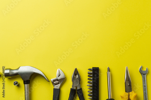 Metal tools on a yellow background, top view, a place to sign photo