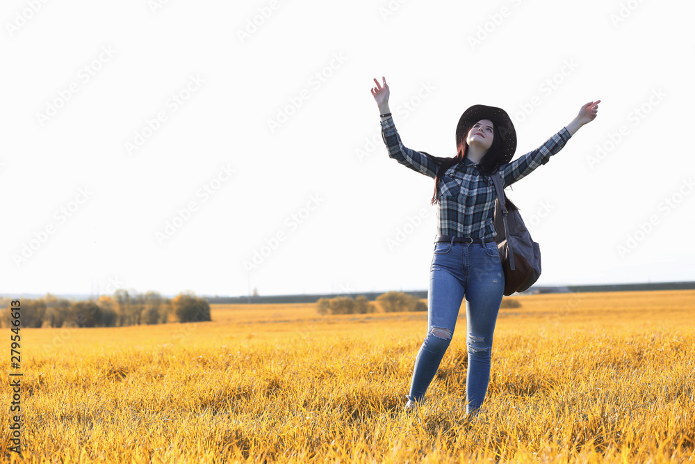 A young girl is traveling around the city hitchhiking. A beautiful young girl went on vacation. A female student in a cowboy hat on the road in autumn. A young girl is traveling around the city hitchhiking. A beautiful young girl went on vacation. A female student in a cowboy hat on the road in autumn.