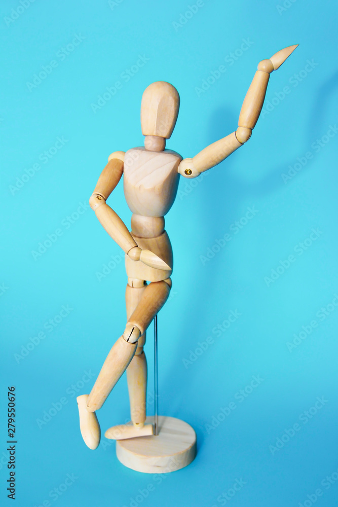 yellow wooden maniken is dancing and doing poses on blue background yellow wooden maniken is dancing and doing poses on blue background