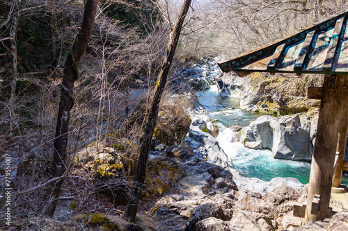 Daiya river flowing water with rocky shore, rocks and gazebo at Kanmangafuchi Abyss of Nikko, Tochigi prefecture in Japan photo