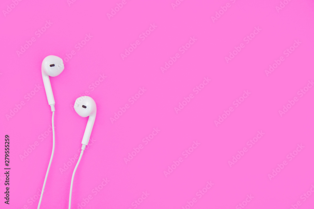 White earphones on pink background with copy space and clipping path. Flat lay. Top view. White earphones on pink background with copy space and clipping path. Flat lay. Top view.