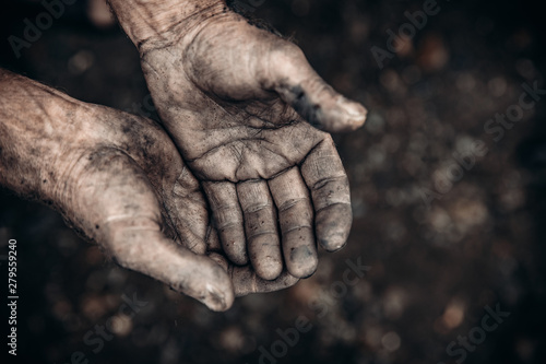 Two palms in mud and calluses are pointing up, hands of refugee and homeless. Concept hard work photo