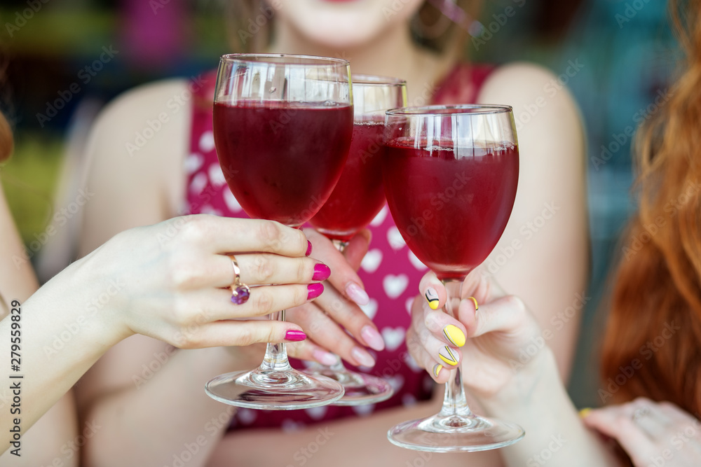 © Olha Tsiplyar - Glasses of red wine in female hands. Toast at a party. The concept of alcohol, holiday