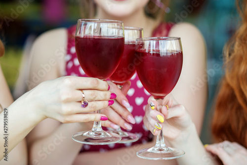 Glasses of red wine in female hands. Toast at a party. The concept of alcohol  holiday
