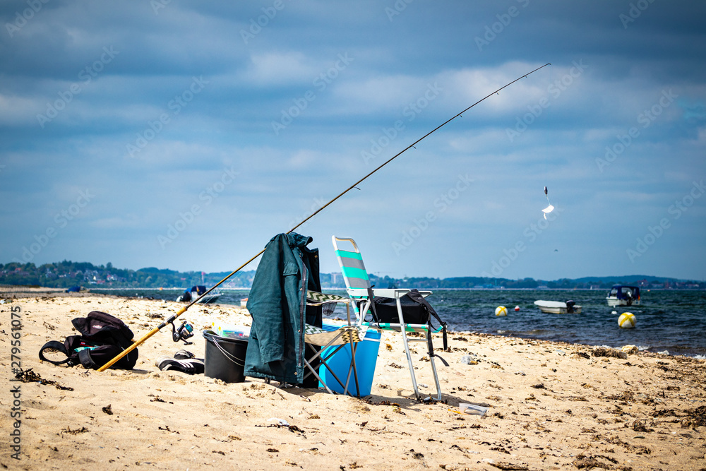 Chair and fishing rod on the beach Chair and fishing rod on the beach