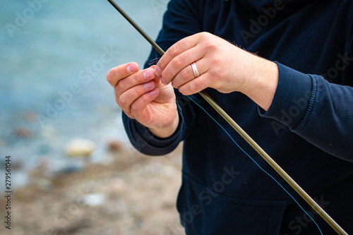 Man attaching hook to fishing line