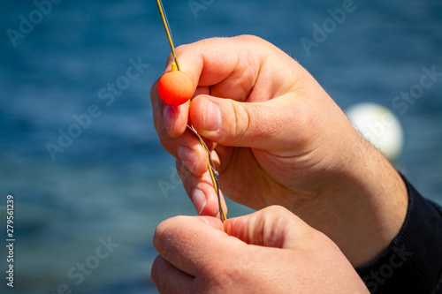 Man attaching bait to fish hook