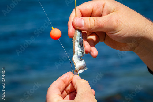 Man attaching bait to fish hook