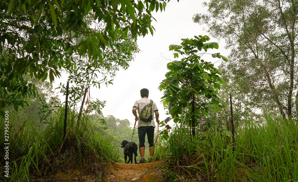 Man and dog standing at a hill top Man and dog standing at a hill top