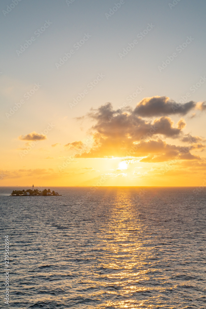 Sunset over small island with light house fire over panoramic scenic island Sunset over small island with light house fire over panoramic scenic island