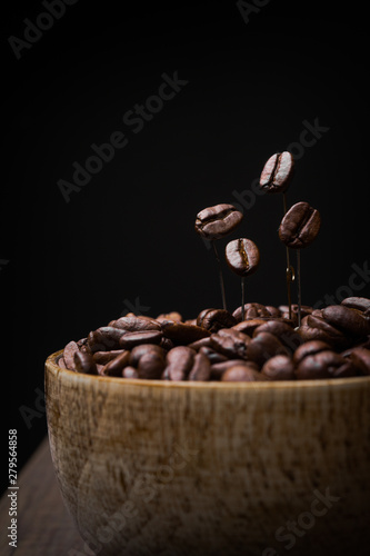 Coffee bean a wooden bowl on dark background