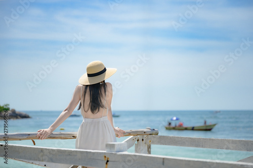 young woman standing on wooden bridge,  enjoy the sea beach in summer vacation and long holidays, tourist in island travel © ID_Anuphon