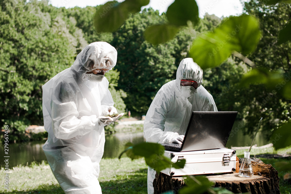 Ecological problem. Pollution. Examine soil. Scientist in protective mask and suit taking water samples from river. Chemist makes an analysis of the environment for radiation. Saving planet earth. ..