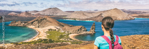Galapagos islands cruise vacation tourist woman panoramic banner. Bartolome or Bartholomew island view on hiking shore excursion travel tourism. Hiker traveling in Ecuador.