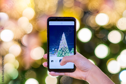 Christmas tree and mobile phone in hand