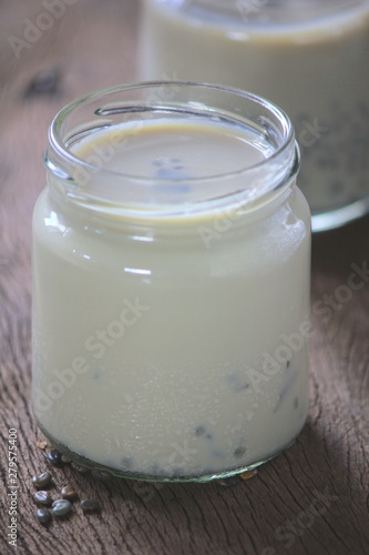 black sesame soy milk in glass on wood