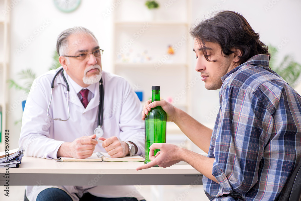 Young male alcoholic visiting old doctor Young male alcoholic visiting old doctor